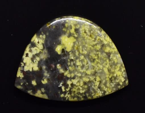 A piece of yellow jasper on a black background.
