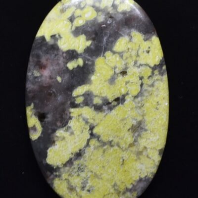 A yellow and black stone cabochon on a black background.