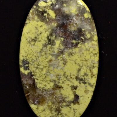 A yellow jasper oval cabochon on a black background.