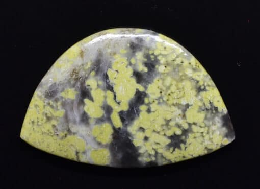 A yellow and black stone pendant on a black background.