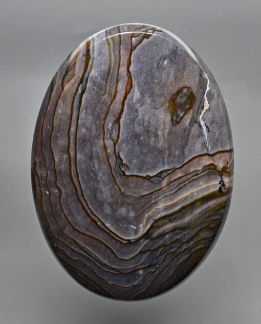A round piece of agate on a gray background.