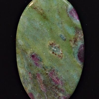 A green and purple stone cabochon on a black background.