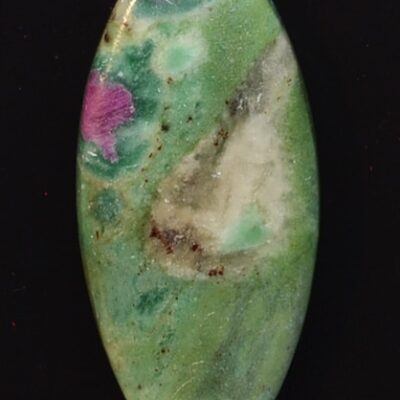 A green and pink stone pendant on a black surface.