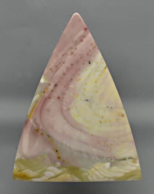 A triangle shaped piece of pink and yellow agate.