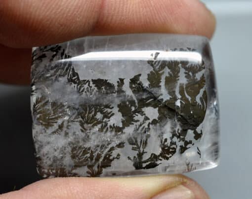 A person holding a piece of quartz with a pattern on it.