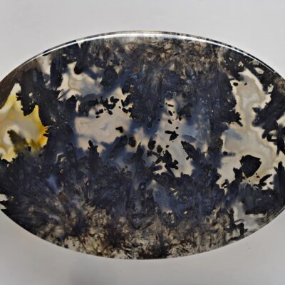 A black and yellow agate plate on a white surface.