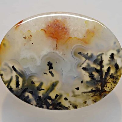 A round piece of agate with a flower on it.