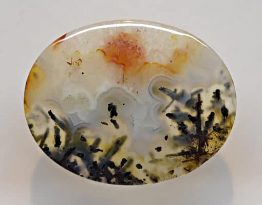 A round piece of agate with a flower on it.