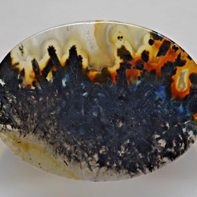 A piece of agate with a black and orange pattern.