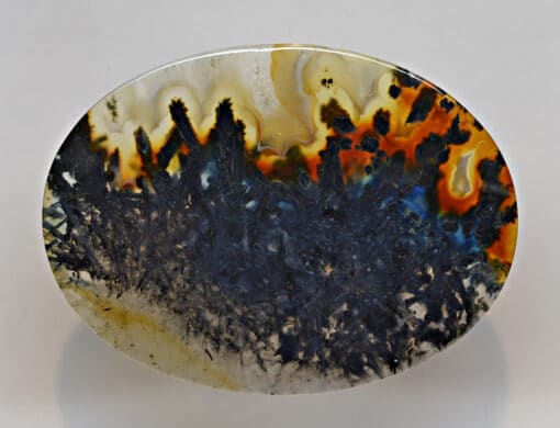 A piece of agate with a black and orange pattern.
