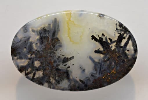 A black and yellow agate on a white surface.