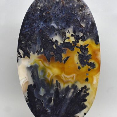 A piece of agate with a yellow and black pattern.