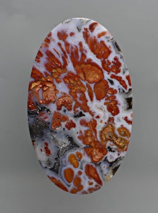 A piece of agate with orange and white swirls.