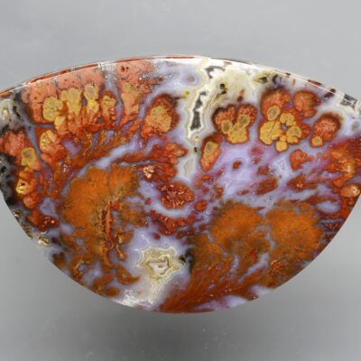 A piece of agate with orange and brown swirls.