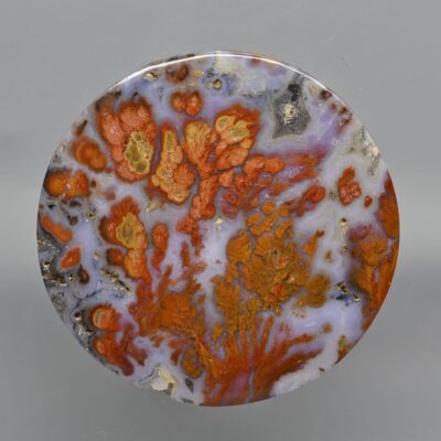 A round piece of orange and brown agate.