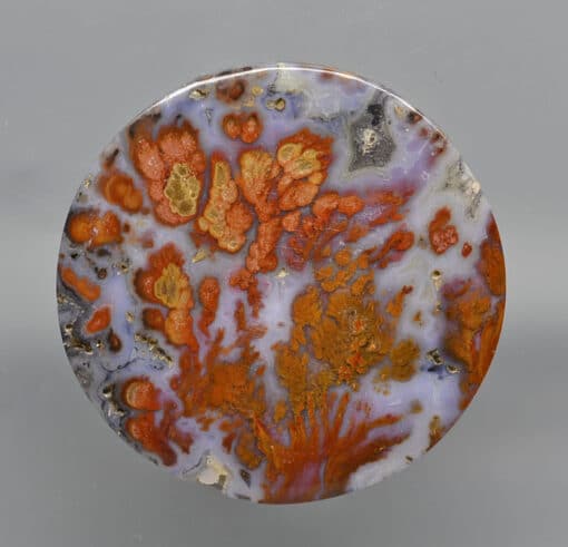 A round piece of orange and brown agate.