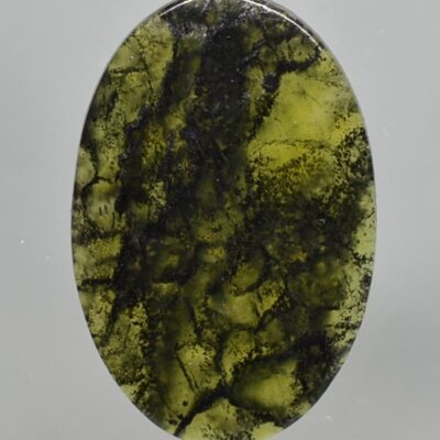 A green stone with black streaks on it.