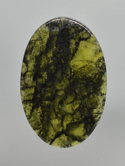 A green stone with black streaks on it.