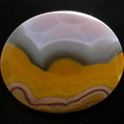 A round piece of agate with a yellow and orange design.