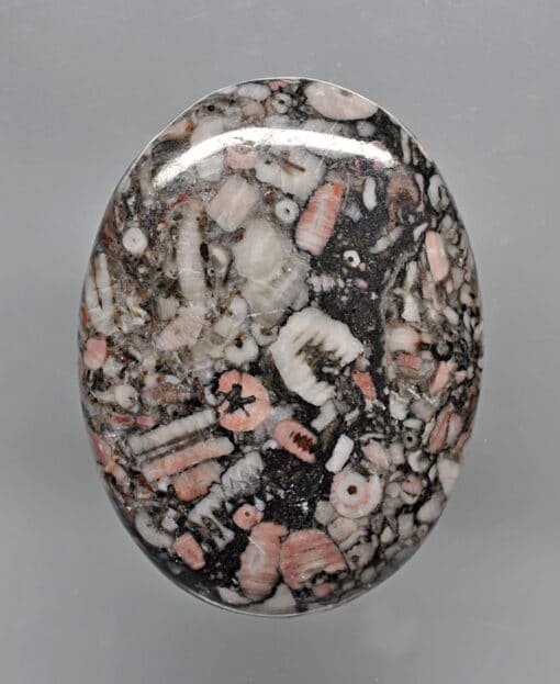 A black and white stone with pink and white specks.