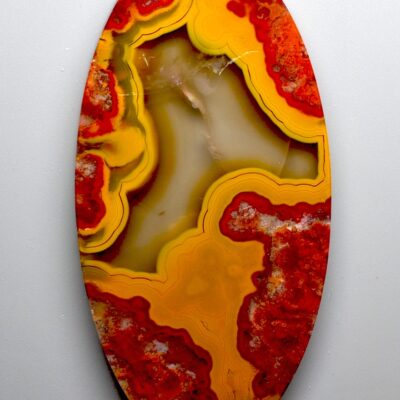 A piece of agate with red and yellow swirls on it.