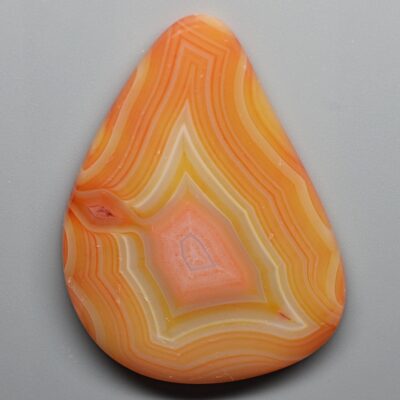 A piece of orange agate on a white surface.