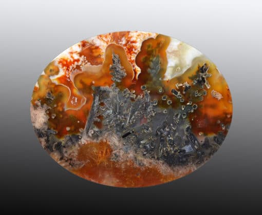 A round piece of agate with orange and black swirls.