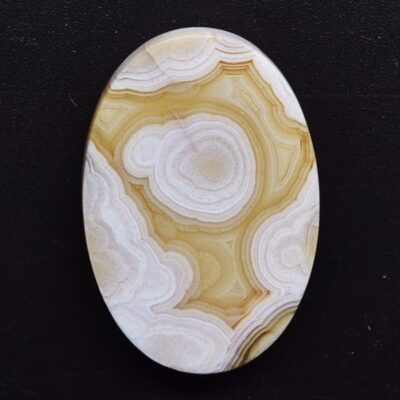 A white and yellow agate oval cabochon.