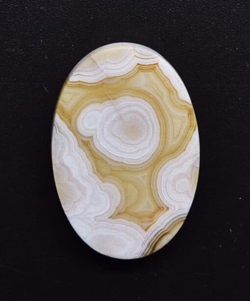 A white and yellow agate oval cabochon.