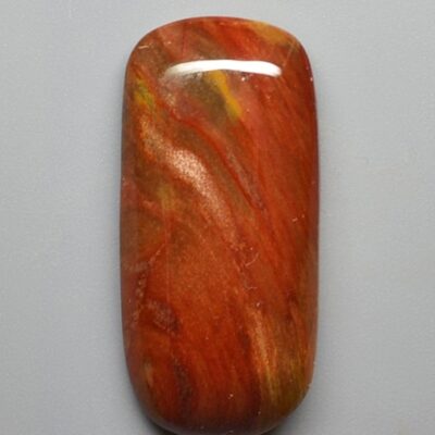 A piece of red jasper on a white surface.