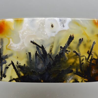 A square piece of agate with a black and yellow design.