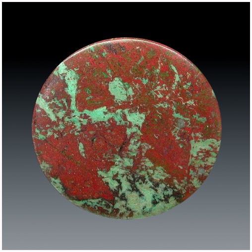 A red and green stone button on a black background.