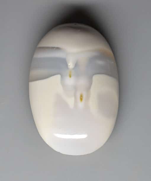 A white agate stone with a hole in it.