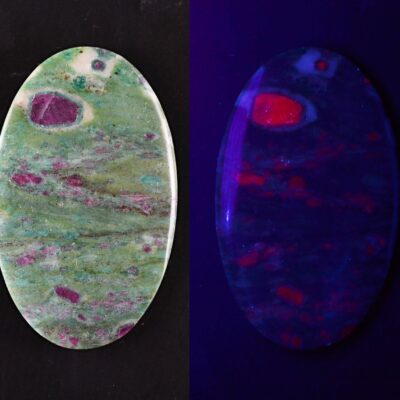 Two oval shaped pieces of opal on a black background.