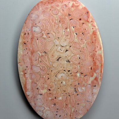 A pink marble plate with a design on it.