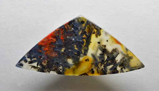 A triangular piece of agate on a white surface.