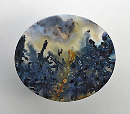 A blue and yellow agate on a white surface.
