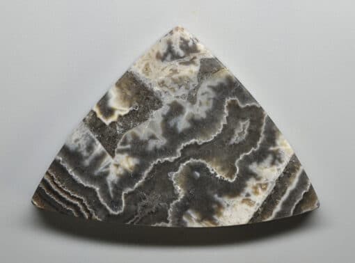 A triangle piece of agate on a white surface.