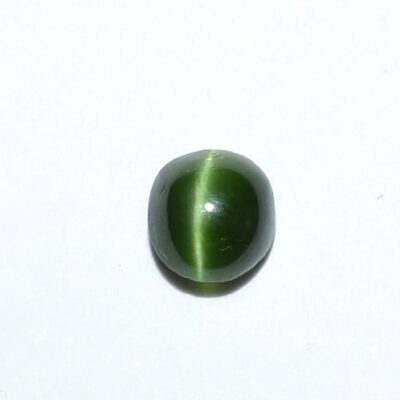 A green tiger eye stone on a white surface.