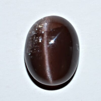 A brown tiger eye stone on a white surface.