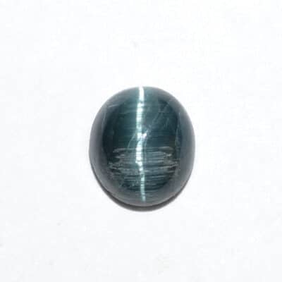 A blue tiger eye stone on a white surface.