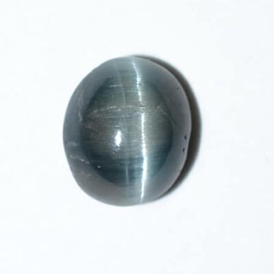 A blue tiger eye stone on a white surface.