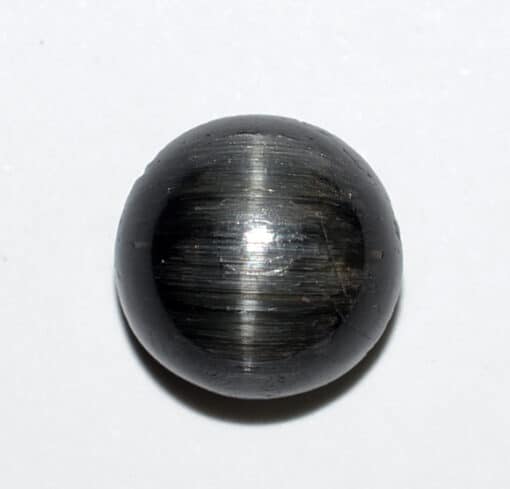 A black stone ball on a white surface.