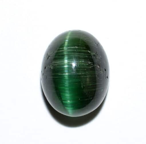 A green tiger eye stone on a white surface.