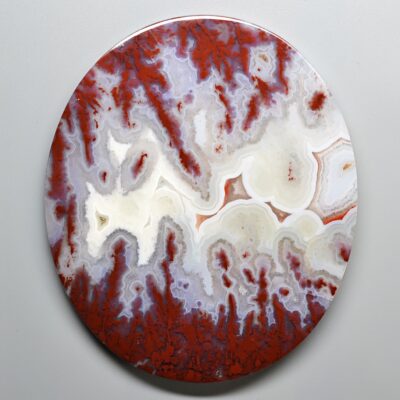 A red and white agate plate on a white surface available for purchase with a valuable discount of 25% for gems valued at $100 or more.