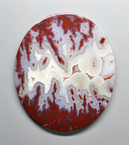 A red and white agate plate on a white surface available for purchase with a valuable discount of 25% for gems valued at $100 or more.