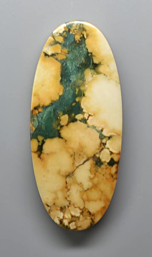 An oval shaped piece of green and yellow jade.