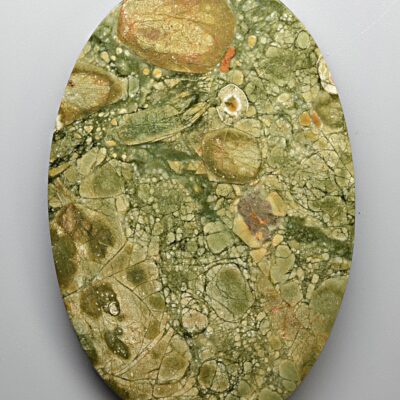 A round piece of green marble on a white surface.