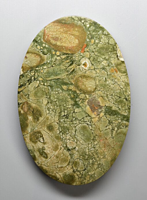 A round piece of green marble on a white surface.