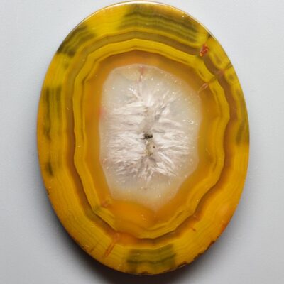 A yellow and white agate on a white surface.